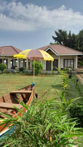 a yellow umbrella in front of a house at Windchime Cottages in Alibaug