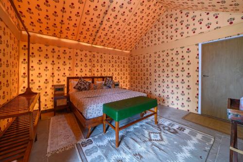 a bedroom with a bed in a room with wallpaper at The Beehad Sariska in Tehla