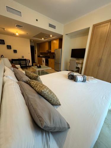 a large white bed with pillows on top of it at Click Stay - JLT - Studio & Balcony Lakes view Entire Apartment -RA in Dubai