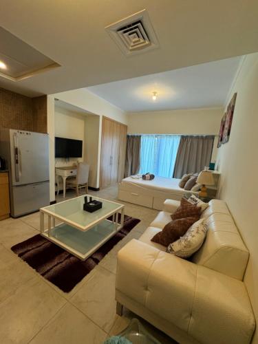 a living room with a couch and a table at Click Stay - JLT - Studio & Balcony Lakes view Entire Apartment -RA in Dubai