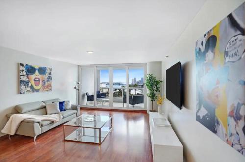 a living room with a couch and a tv at The Grand Biscayne Bay in Miami