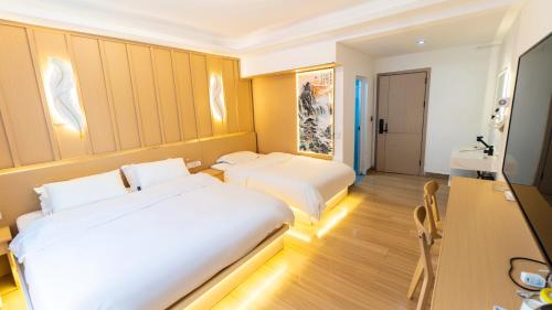 a hotel room with two beds and a flat screen tv at Yibuxuan Boutique Hotel Yangshuo in Yangshuo