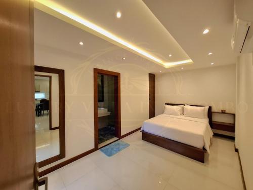 a bedroom with a white bed and a mirror at Luxury Villa in Colombo in Rajagiriya