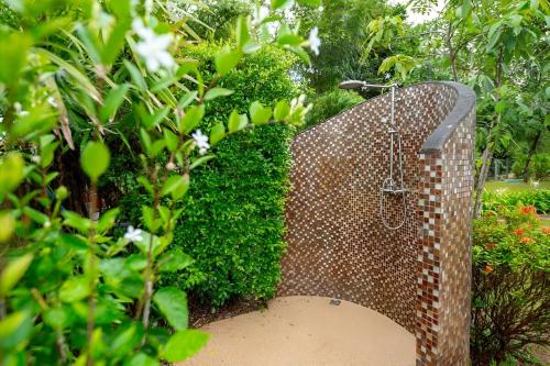 a stone wall with a swing in a garden at Sriwaree Pool Villa Khao Lak - 8 meters pool - 3 bedroom - 2 bath in Khao Lak