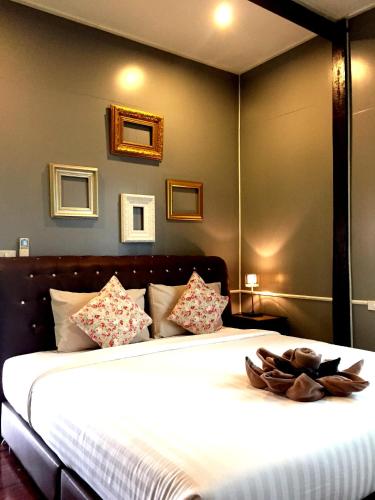 a bedroom with a large bed with white sheets at Aen Guy Boutique Hotel in Sukhothai
