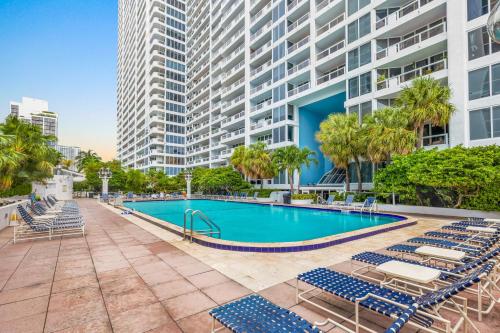 a swimming pool with lounge chairs and a large building at The Grand Biscayne Bay in Miami