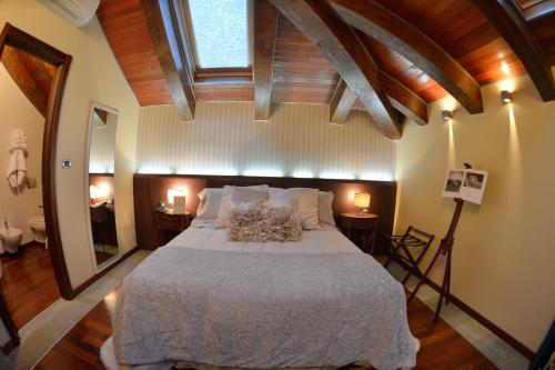 a bedroom with a large bed with a wooden ceiling at Hotel Dei Pittori in Turin
