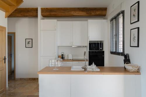 une cuisine avec des armoires blanches et un comptoir en bois dans l'établissement Maison Castel A haven of peace near Deauville, à Cricquebœuf