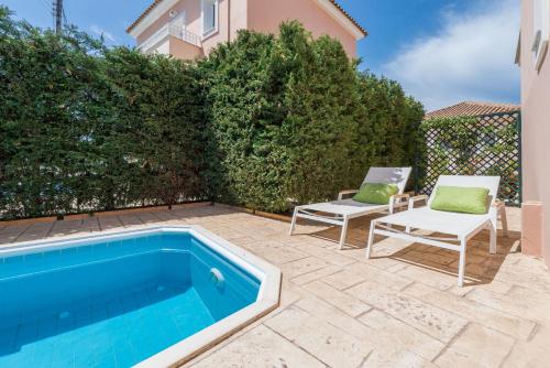 a swimming pool in a yard with two chairs at Lorenzo Villas with Private Pool, 200m from the beach, by ZanteWize in Lithakia
