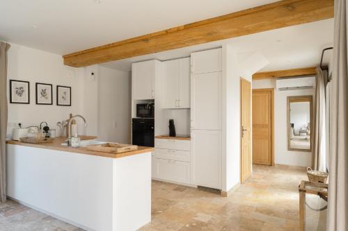 une cuisine avec des armoires blanches et un comptoir dans l'établissement Maison du Haras Norman house near Deauville, à Cricquebœuf
