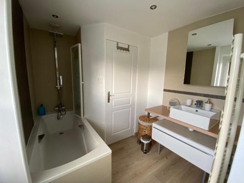 Un baño con bañera, lavabo y bañera. en La Petite Maison, jardin et jacuzzi, proche de Lyon, en Charly
