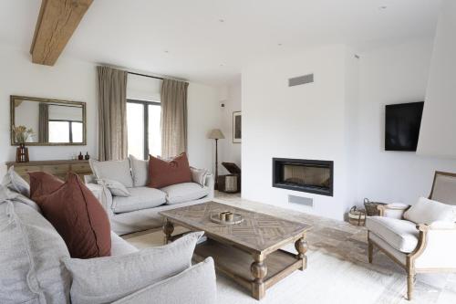 un salon avec un canapé et une table basse dans l'établissement Maison des Pommiers Elegant house near Deauville, à Cricquebœuf