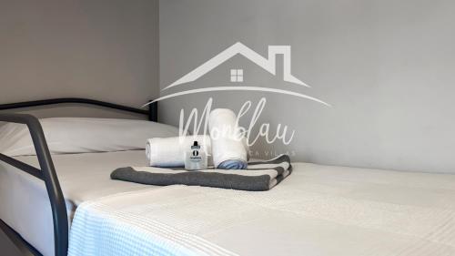 a bedroom with two beds with a home sign on the wall at Ses Orenetes in Cala en Blanes