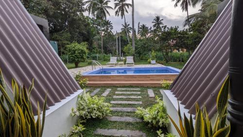 a backyard with a swimming pool and a garden at Palm serenity villa in Tangalle
