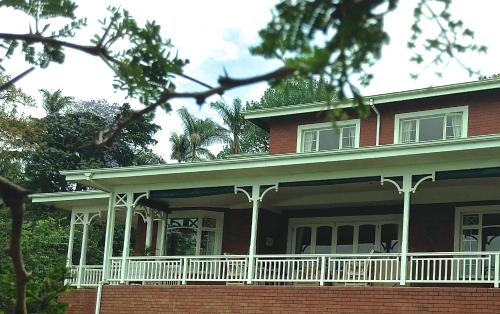 a red brick house with a white porch at Southey House in Kloof