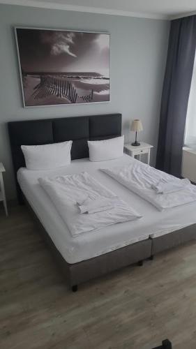 a large bed in a bedroom with a white mattress at Appartement-Hotel Rostock in Rostock