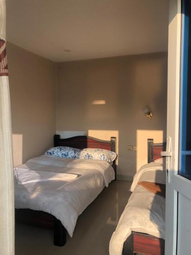 KāskīにあるInto The Wild Pokharaの部屋にベッドが2つある寝室