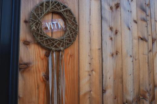 a door with a wreath on a wooden wall at Moderne Tiny Houses am Weingut in Uelversheim