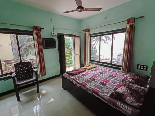 a bedroom with a bed and a chair and windows at holiday homes in Murud