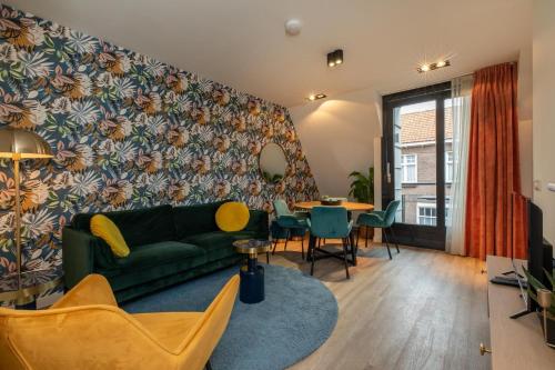 a living room with a green couch and a table at Welcome in - Onderaan de duinen, in het centrum - Langstraat 29 Zoutelande in Zoutelande