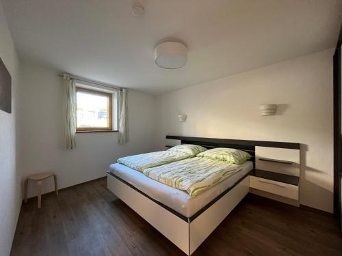 a bedroom with a bed and a window at Ferienwohnung Haus Brenner in Seeg
