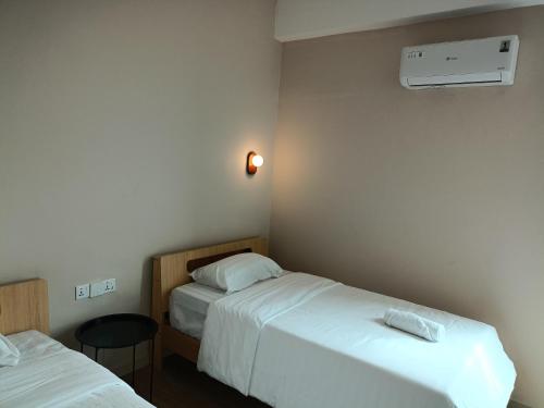 a hotel room with two beds and a air conditioner at Keteri Boutique Hotel in Kangar
