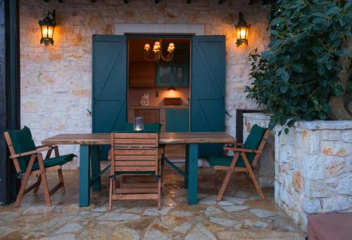 Una mesa y sillas frente a un edificio. en Olivia on Sea, en Agios Spiridon, Corfú