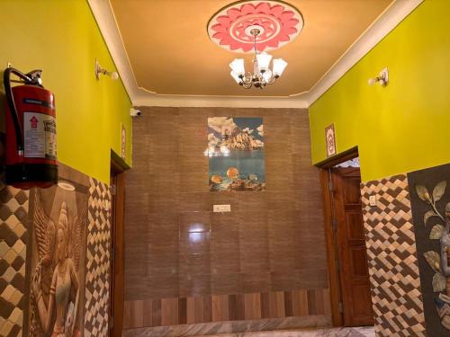 a bathroom with a shower with yellow walls and a chandelier at Dee Dash Inn in Bhubaneshwar