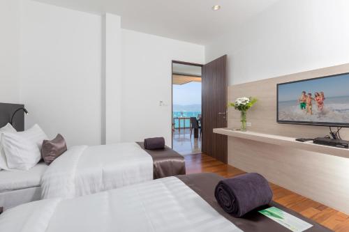 a hotel room with two beds and a flat screen tv at X10 Seaview Suites at Panwa Beach in Panwa Beach