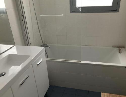 a bathroom with a white tub and a sink at Cap Ferret Océan - Réf 52 in Lège-Cap-Ferret
