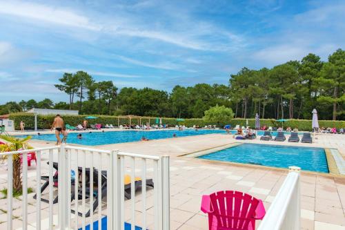 - une piscine avec des chaises dans l'établissement Chalet A Village Vacances, à Gujan-Mestras