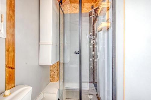 une salle de bain avec une douche avec une porte vitrée dans l'établissement Chalet A Village Vacances, à Gujan-Mestras