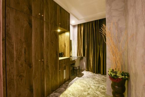 a hotel room with a desk and a chair in a room at Belle Song Motel in Shulin