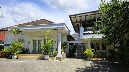 a white house with plants in front of it at Surokarsan 9 House Yogyakarta in Yogyakarta