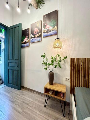 a room with a table and a potted plant on a wall at Old Quater Tropical House in Noi Bai