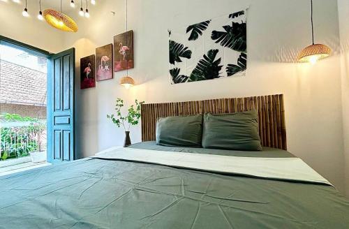 a bedroom with a large bed with green sheets at Old Quater Tropical House in Noi Bai