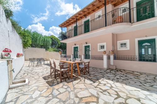 a patio of a house with a table and chairs at Spyridoula Studio 1 in Paleokastritsa