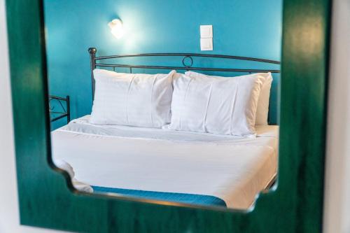 a reflection of a bed with white pillows in a mirror at Spyridoula Studio 4 in Paleokastritsa