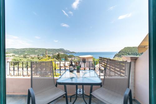 a table and chairs on a balcony with a view of the ocean at Spyridoula Studio 4 in Paleokastritsa