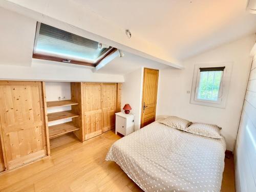 une chambre avec un lit et une lucarne dans l'établissement La cigale - Maison avec piscine, à Nîmes