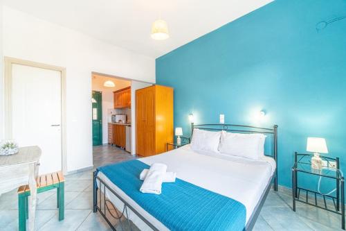 a bedroom with a large bed and a blue wall at Spyridoula Studio 4 in Paleokastritsa