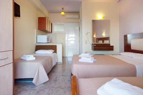 a hotel room with three beds and a kitchen at Zante View Family Studio 2 in Tsilivi