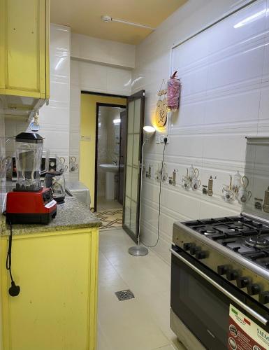 a kitchen with a stove and a yellow counter top at Apartment near bus station & market MEN only in Sharjah