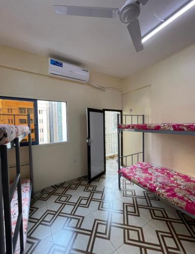 a room with two bunk beds and a door at Apartment near bus station & market MEN only in Sharjah