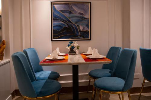 a dining room with a table with chairs and a painting at Hanoi Fiesta Central Hotel and Spa in Hanoi