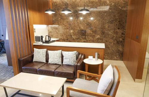 a living room with a couch and a table at Hotel Skypark Central Seoul Pangyo in Seongnam