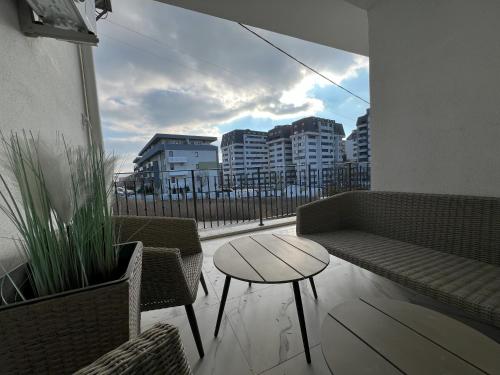 a balcony with a couch and a table and chairs at COLLINE Rezidențial in Rediu