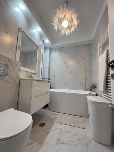 a bathroom with a tub and a toilet and a sink at COLLINE Rezidențial in Rediu