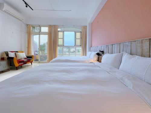 a large white bed in a room with a large window at Summer Station in Hualien City