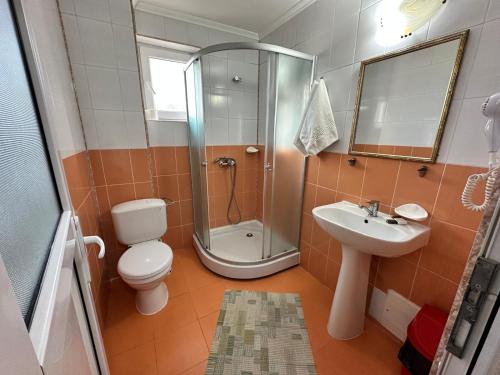 a bathroom with a shower and a toilet and a sink at Pensiunea La Vasile in Zalău